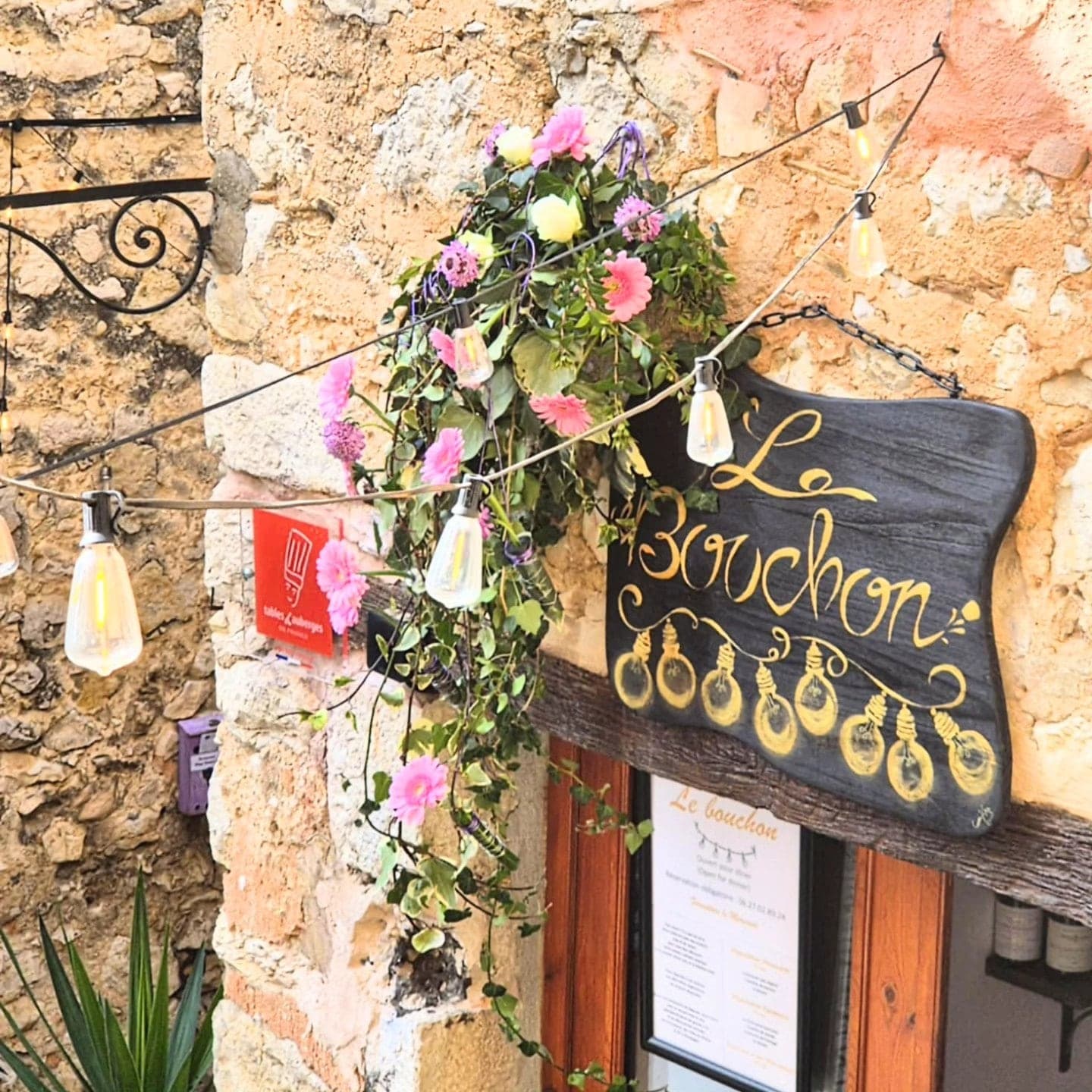 La façade du Bouchon, avec son enseigne, ses fleurs et sa guirlande